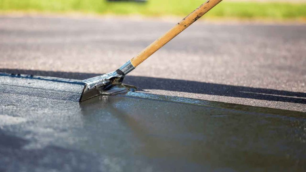 Applying dark protective driveway coating with a squeegee tool